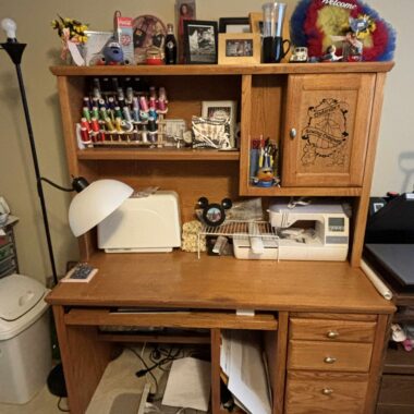 Colorful sewing desk with Disney-themed decor and craft supplies for Disney fashion fans and sewing enthusiasts.