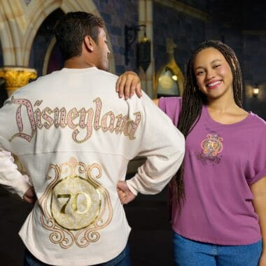 Couple at Disneyland wearing 70th anniversary-themed clothing with "Disneyland" logo.