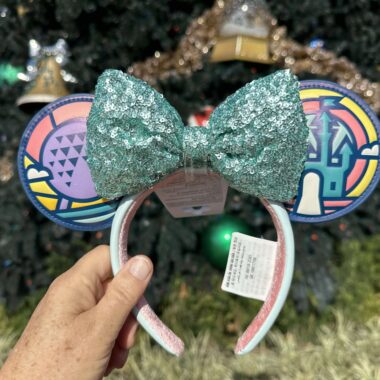 Vibrant Minnie Mouse headband with glittery teal bow, rainbow-patterned ears, perfect for Disney fashion lovers.