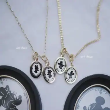 Delicate gold chain necklace with Mickey and Minnie silhouette pendants, perfect for Disney fashion lovers.