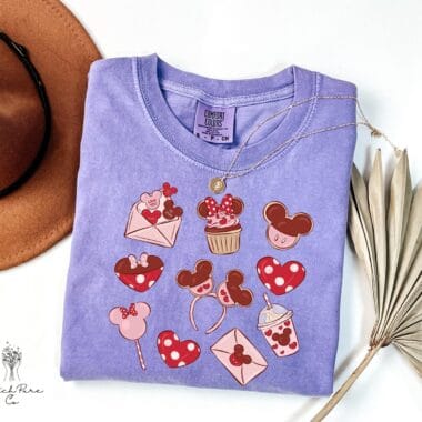 Colorful Disney Minnie Mouse Valentine's Day graphic tee with hearts, cupcakes, and love-themed icons.