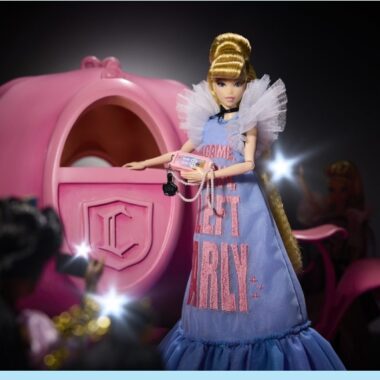 Enchanted Disney fashion doll in a letter girl dress with a pink carriage backdrop, perfect for Disney fan collectibles and fashion enthusiasts.