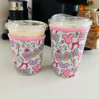 Disney-themed reusable travel mugs with Minnie Mouse designs, pink accents, and secure lids.