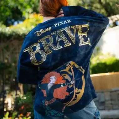 Woman wearing a Disney Pixar Brave denim jacket outdoors.