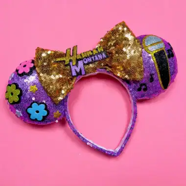 Sparkly Minnie Mouse headband with bow, flowers, and musical notes on pink background.