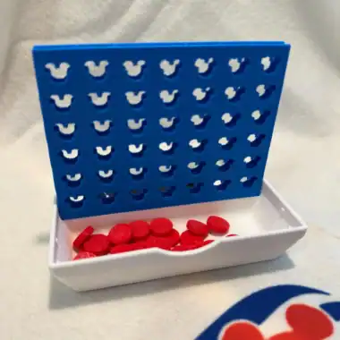 Disney-themed Connect 4 game with red pieces in a white tray.
